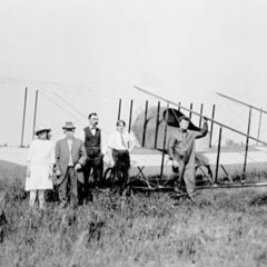 Un groupe de personnes au tour d'un avion biplan.