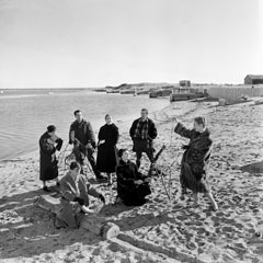 Groupe d'hommes et de femmes sur la plage.