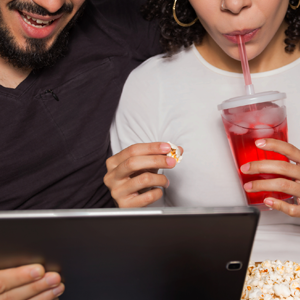 Un couple regarde des séries sur une tablette numérique.