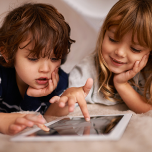 2 enfants regardent une tablette.