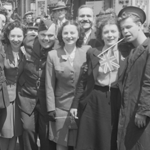 Photo en noir et blanc de femmes et d'hommes à la fin de la 2nde guerre mondiale.