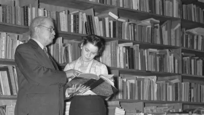 Un homme et une jeune femme devant une grande bibliothèque remplie de livres